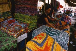 Stacked wax-print fabrics at a market stall