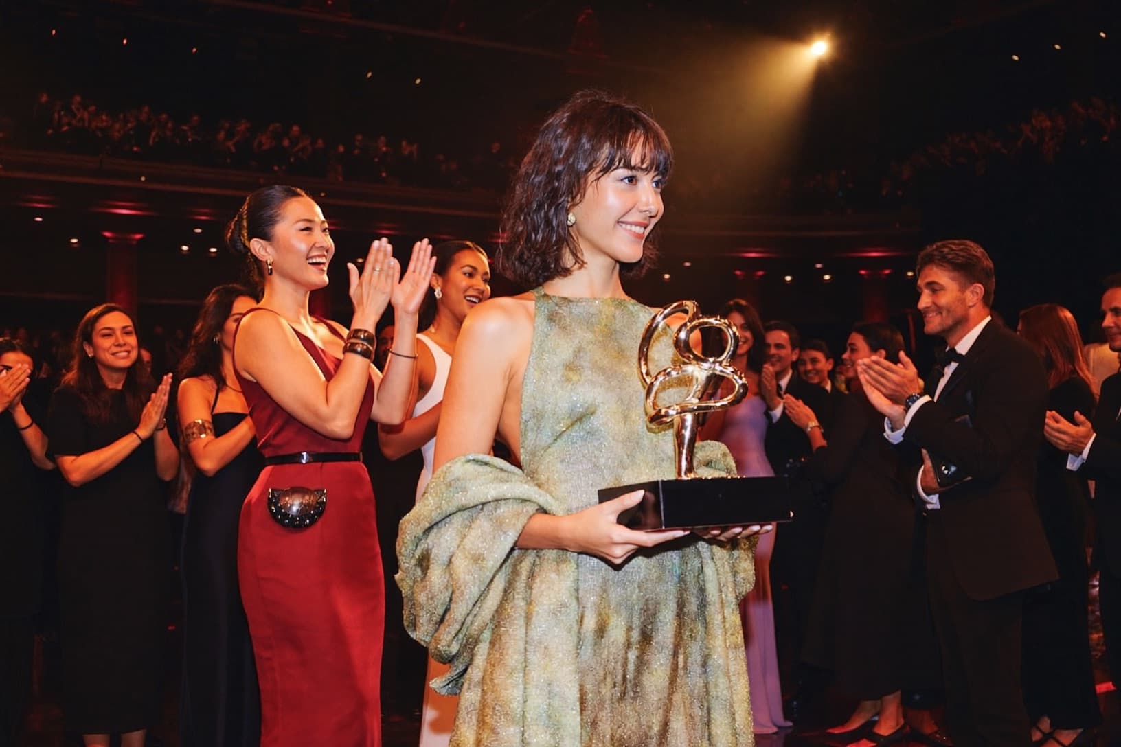 A winner raises a trophy on stage at an awards gala