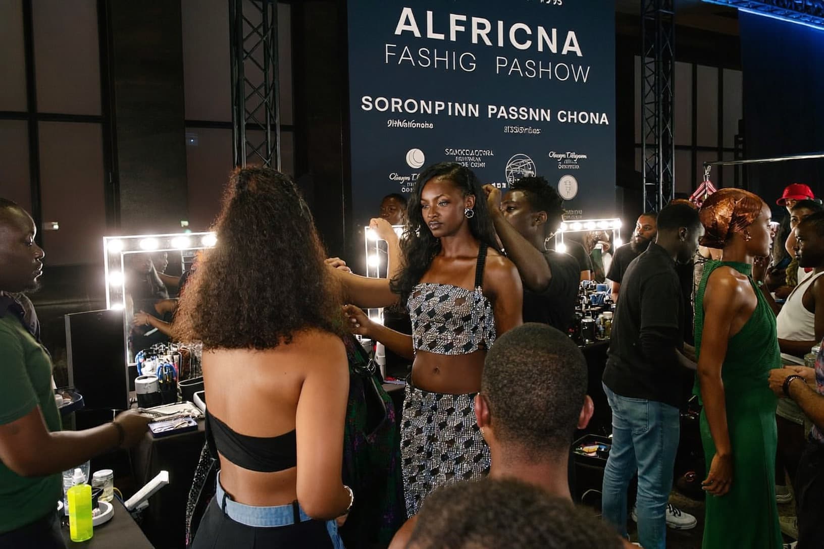 Dressers pin and adjust garments on models backstage before a show.